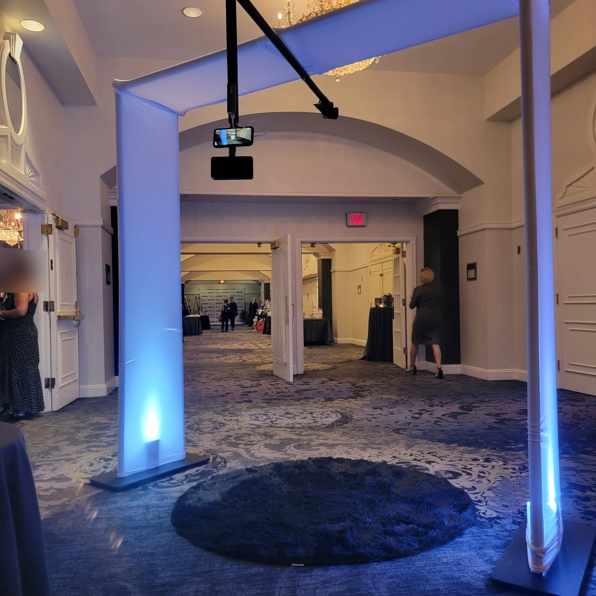 Overhead 360 photo booth rig with glowing columns in a hotel hallway