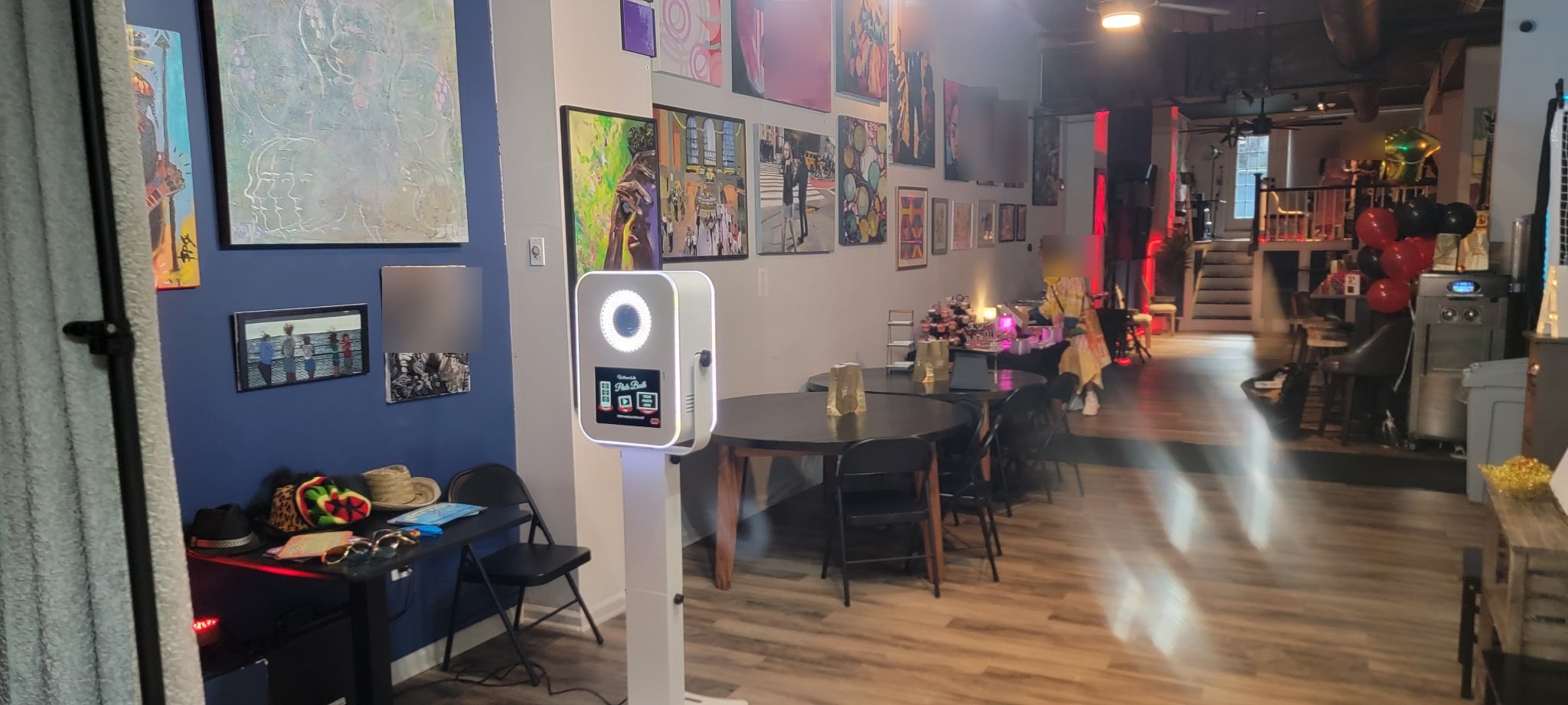 Photo booth kiosk with green accent lighting and printer on site