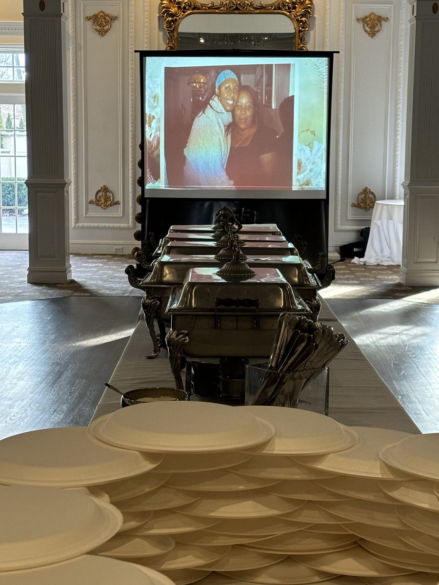 Projector screen showing a memorial photo tribute at a repast
