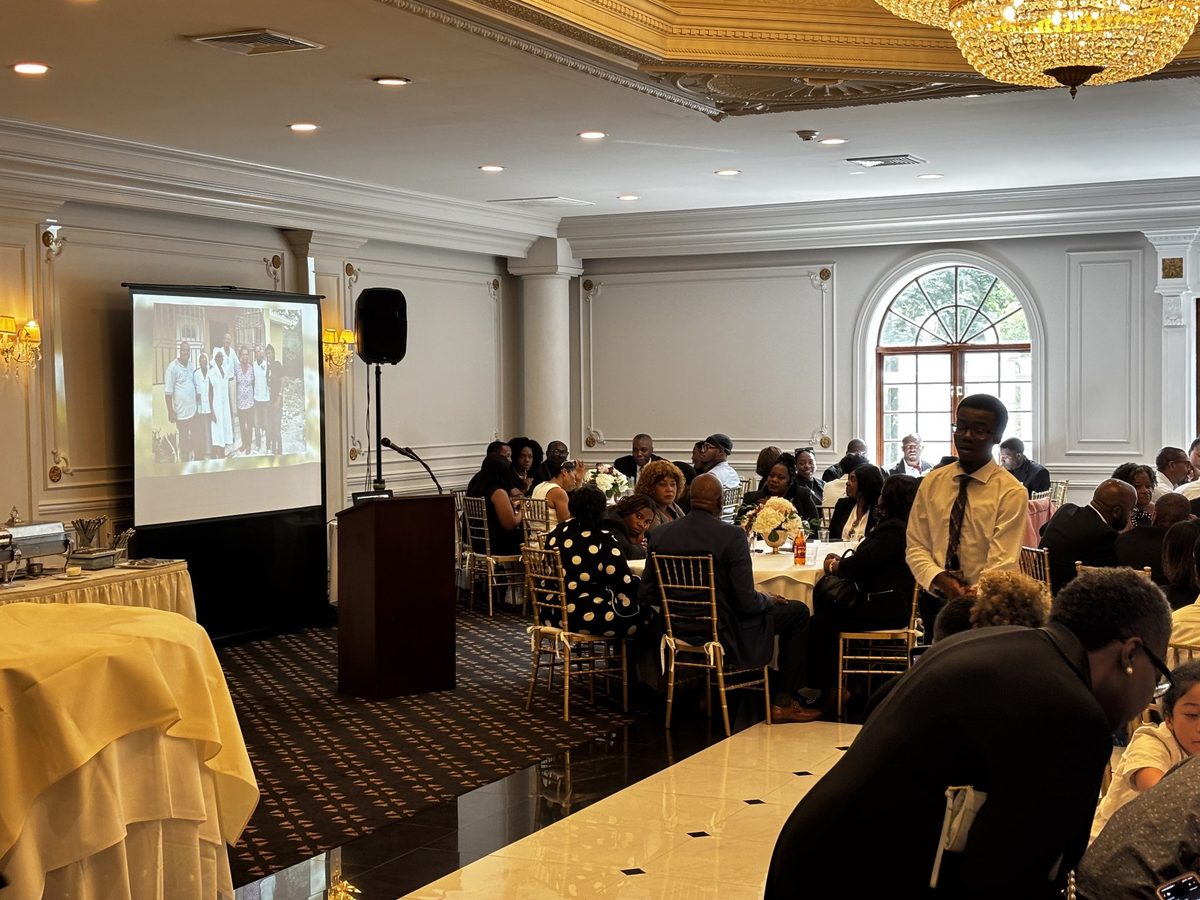 Guests watching a memorial photo tribute on a projector screen at a repast