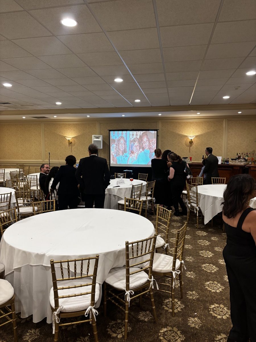 Memorial tribute displayed on a large screen in a decorated banquet hall
